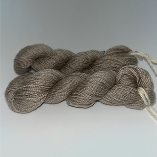Two skeins of twisted yarn in a taupe-brown color, displayed on a neutral light gray background.