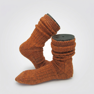A pair of rust-orange ribbed knit socks displayed on invisible foot forms against a light gray background.