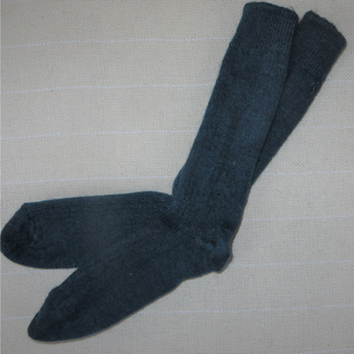 A pair of dark navy blue ribbed knit socks laid flat on a light beige textured fabric background.