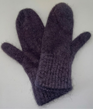 A pair of dark purple knit mittens with a fuzzy mohair-like texture, laid flat on a light gray background.