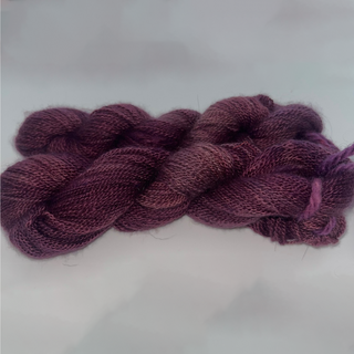 A skein of twisted yarn in a heathered plum-purple color, displayed on a light gray background.