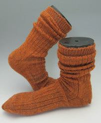 A pair of knit orange knit socks with ribbed cuffs, displayed on a light gray background.