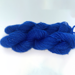 skeins of vivid royal blue yarn on a plain white background.