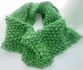 A bright green crocheted cowl scarf with a textured, openwork pattern, displayed on a clean white background.