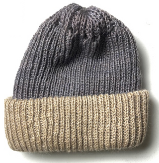 A hand-made knit beanie hat featuring a dark gray upper section with a textured knit pattern and a contrasting beige ribbed cuff, shown against a plain white background.
