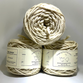 Three skeins of yarn stacked on a white background with labels.