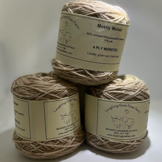 Three skeins of TAN yarn stacked on a white background with labels.