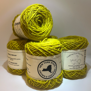Four skeins of bright yellow wool yarn stacked together, each with a paper label. The labels show the brand New York State Grown & Certified and names such as  Laughing Goat Fiber Farm.